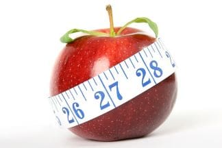 An apple with a tape measure around it