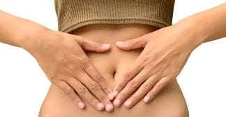A fit and healthy lifestyle woman holding her stomach with IBS