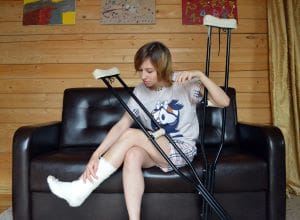 Woman with toned legs on crutches with an injured ankle