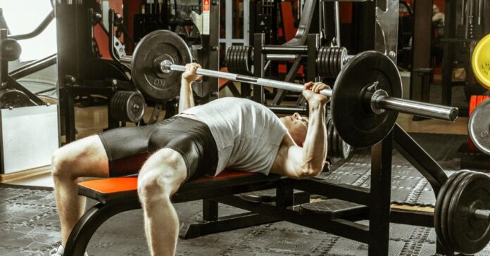 Picture of a man doing a barbell bench press.