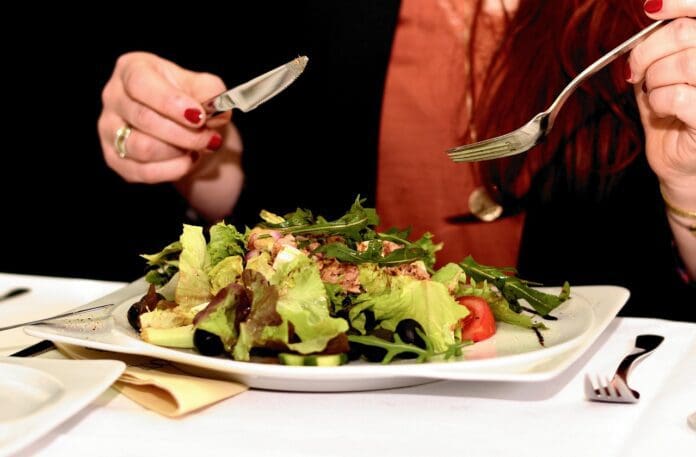 Picture of a woman eating a salad. General Nutrition Versus Personalized Nutrition
