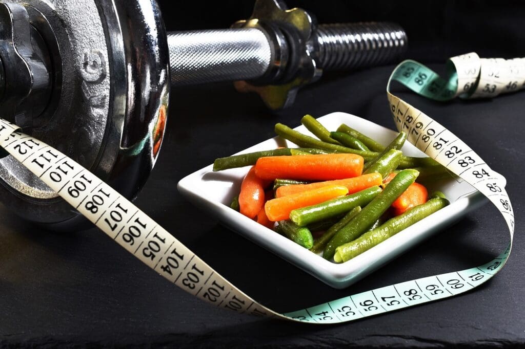 Picture of dumbbells and a nutritional dinner. Exercise and Life Expectancy and exercise, physical activity