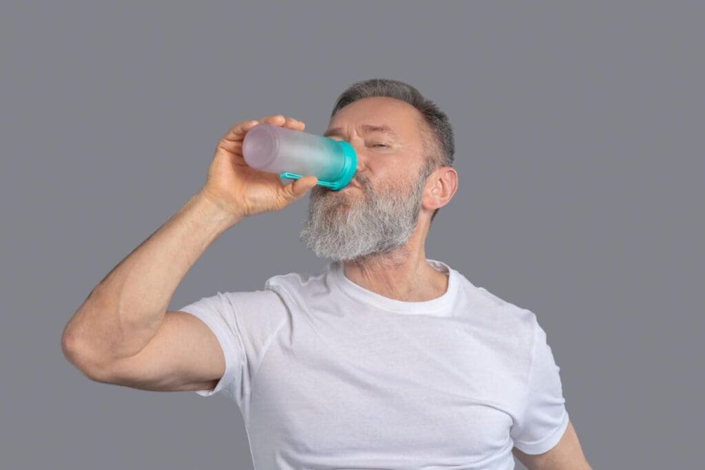 Picture of an older man drinking a protein shake. Best Muscle Building supplements for men over 60