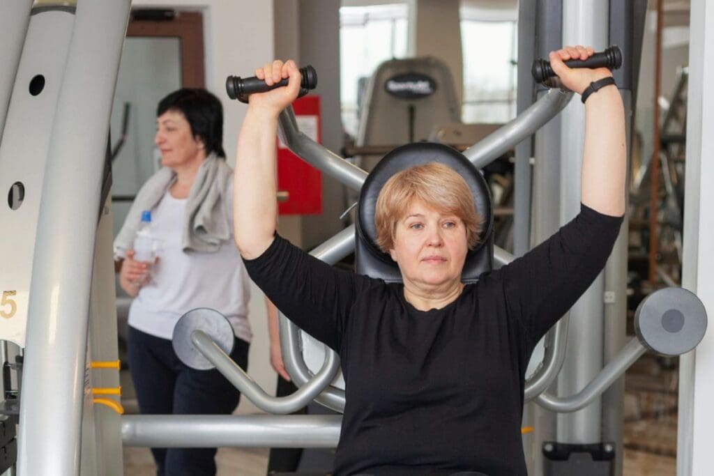Woman doing a shoulder press. Women Over 50 a whole body program
