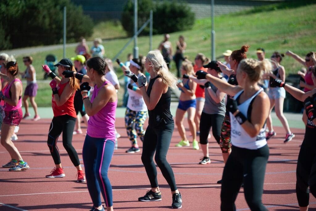 Women doing a Zumba Class for cardio outdoors.